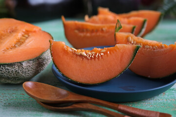 sliced organic melon on blue plate - closeup
