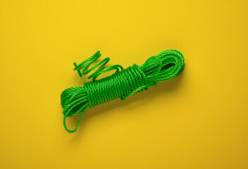 nylon rope of green color on yellow background - isolated - closeup