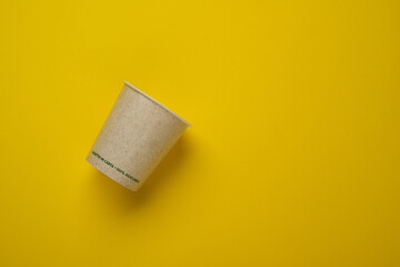 recyclable paper cup on yellow background - isolated - closeup
