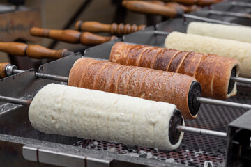 Hungarian chimney cake wrapped around a truncated cone–shaped baking spit, and rolled in...