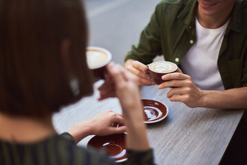 Young lovely couple drinking coffee and chatting. Friends and love concept. Coffee break with cup of Latte. Background