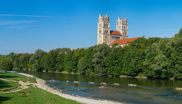 Panoramaansicht der Isar in M&uuml;nchen mit den beiden T&uuml;rmen der katholischen Kirche St. Maximilian bei wolkenlosem, blauen Himmel im Sommer
