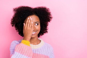 Fototapeta na wymiar Photo of positive good mood girl with perming coiffure wear knit sweater look empty space arm cover eye isolated on pink color background
