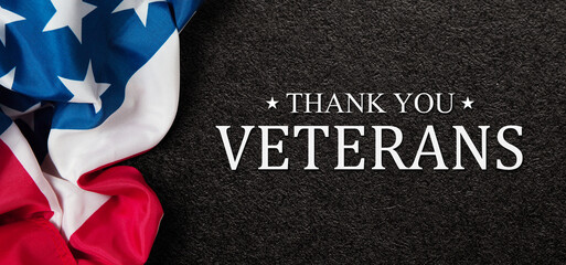 Closeup of American flag with Text Thank You Veterans on black textured background. American...