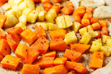 Oven-baked vegetables on a baking sheet. Baked pumpkin, potatoes, carrots and onions. Cooking dinner in the oven. Vegetarian food in the oven. Vegan cuisine. Proper and healthy nutrition
