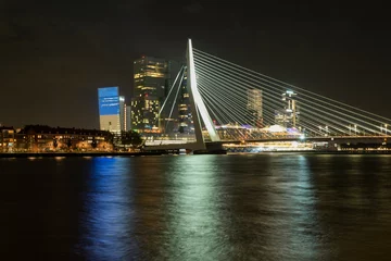 Rolgordijnen Erasmusbrug cable-stayed bridge over the Maas river in the center of Rotterdam with city view and reflection at night © Sheviakova