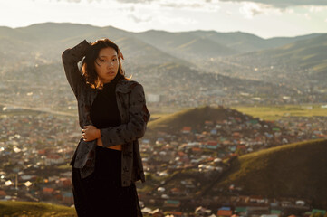 Mongolian fashionable young women with Ulaanbaatar on background. Fashion concept.