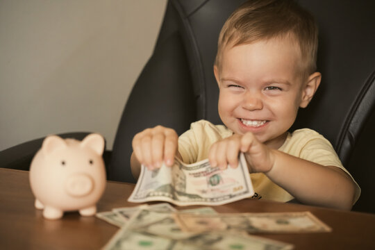 Child holding dollar banknote near piggy bank. Smart happy boy saving money in a piggy bank, learning about saving. Money, finances, insurance, and people concept