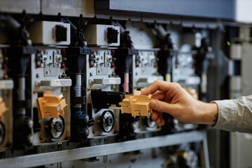 Close up of worker setting up industrial printing machines with focus on complex tech parts, copy space
