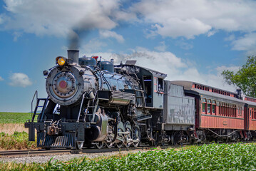 View of an Antique Restored Steam Passenger Train Approaching Along a Lone Rail Road Track...