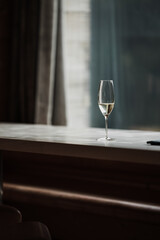 A class of champagne on a wooden window with a dark moody feel to it