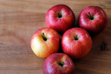 five red apples on a wooden table, fresh apples on a wooden background