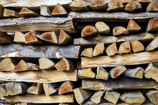 Chopped firewood is stacked in neat piles. Woodpile. Background. Close-up. Selective focus.