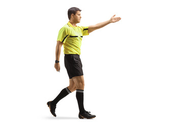 Full length profile shot of a football referee pointing with hand and walking