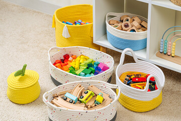 Nursery room with shelves and colourful storage baskets. Rainbow wooden toys. Space organizing at...