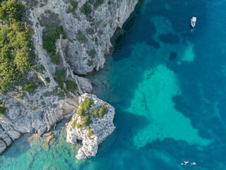 Aerial view of a boat moored near the coast of the island of Corfu, crystal clear sea. Greece