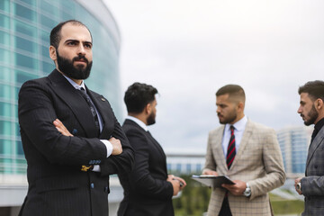 Business people outdoor meeting. Portrait of a business man against the background of a group of people and buildings of the city center