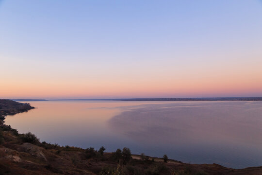 Stunning pink sunset over the lake, sunset background. Khadzhibey Estuary near to the city Odesa, Ukraine.