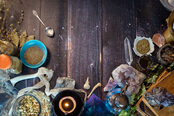 Occult altar with cristals, snake skin, potions, herbs, bones, skulls and old books. Esoteric alchemy, pagan, Wicca, witchcraft background with magical objects. Halloween concept. Top view, copy space