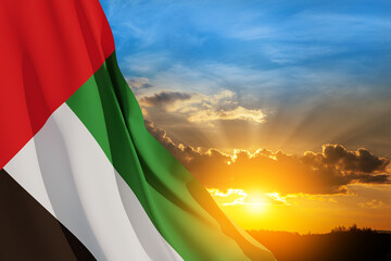 Flag of United Arab Emirates on background of sunset sky. UAE celebration. National day, Flag day,...