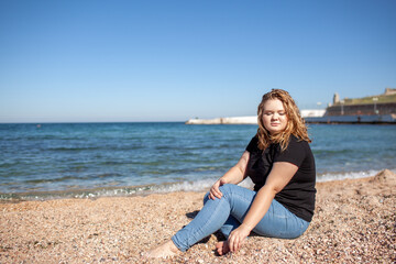 Beautiful plus size woman walking in the beach, resting and enjoy the moment to be alone and meditate near the sea or ocean in the beach. Overweight woman dressed jeans and t-shirt