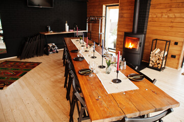 Table with paltes and candies in modern wooden house with fireplace.