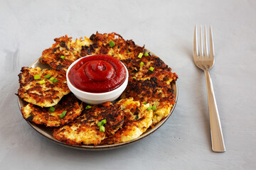 Homemade Cauliflower Cheddar Fritters with Chives on a Plate, side view.