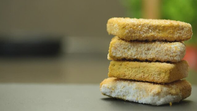 Fish sticks. The process of cooking fish sticks in a pan, close-up. Breaded fish fillet.