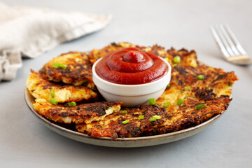 Homemade Cauliflower Cheddar Fritters with Chives on a Plate, side view. Close-up.