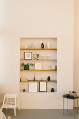 Stylish shelves in the living room wall, on which there is a decor for Christmas and New Year