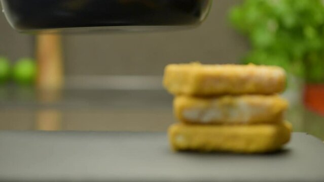 Fish sticks. The process of cooking fish sticks in a pan, close-up. Breaded fish fillet.