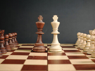 Chess on a black background the chess king face to face on the chessboard with the rest of the...