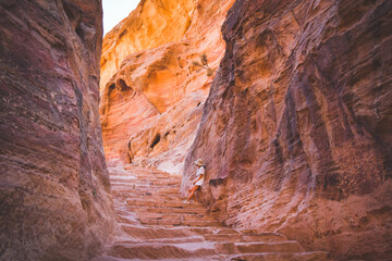 Caucasian tourist girl stand on staircase to A'dir monastery on mountain in Petra lost city...