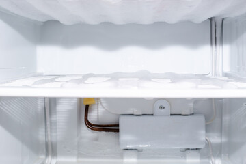 Freezer compartment with frozen ice and evaporator, selective focus. Defrost fridge and freezer - obrazy, fototapety, plakaty