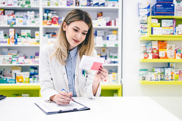 Obraz na płótnie Canvas Portrait of young female pharmacist worker in pharmacy store 