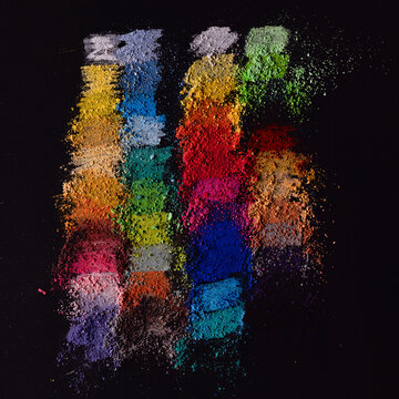 Overhead view of multi coloured chalk powder on a blackboard