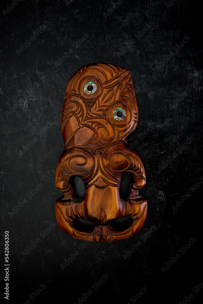 Wall mural wooden maori hei tiki hand carved with paua shell eyes. new zealand taonga.