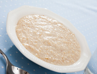 Lenten boiled oatmeal served on white plate. Dietary concept ..
