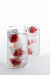 Refreshing drinks with strawberries in ice on a white background