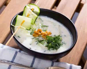 Traditional Bulgarian cold vegetable soup Tarator with cucumber, walnuts, garlic and yogurt in...