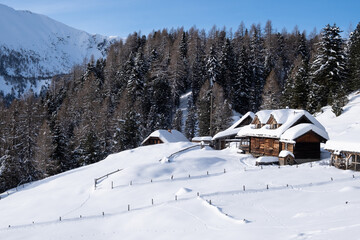 wooden alpine hut in deep snowy landscape