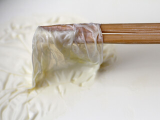 milchhaut mit holzstäbchen abnehmen