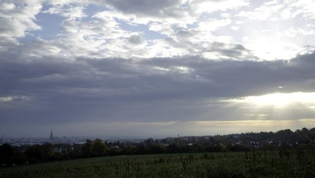 City of Ulm from west with sunlight shining through heavy clouds time lapse