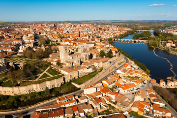 Scenic drone view of ancient walled Spanish city of Zamora on bank of Duero River overlooking Romanesque medieval cathedral on sunny spring day - obrazy, fototapety, plakaty