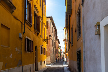 Fototapeta na wymiar A narrow street of shops and cafes in the historic medieval old town center of Verona, Italy. 