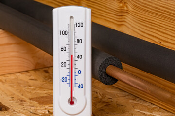 Water pipe with insulation and thermometer in house. Plumbing freezing protection, energy savings...