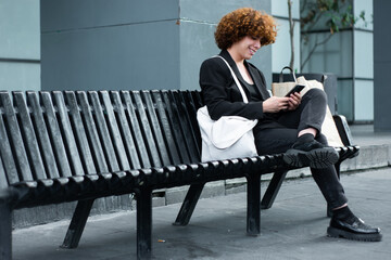 A non-binary person is reviewing the smartphone and the broker app status 
