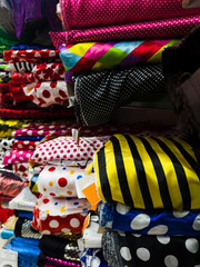 Fabric Store, Traditional fabric store with stacks of colorful textiles, fabric rolls at market stall - textile industry.