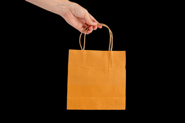 Hand Holding Paper Bag isolated on black background.