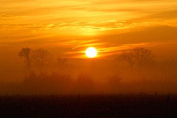 sunrise over a farm field